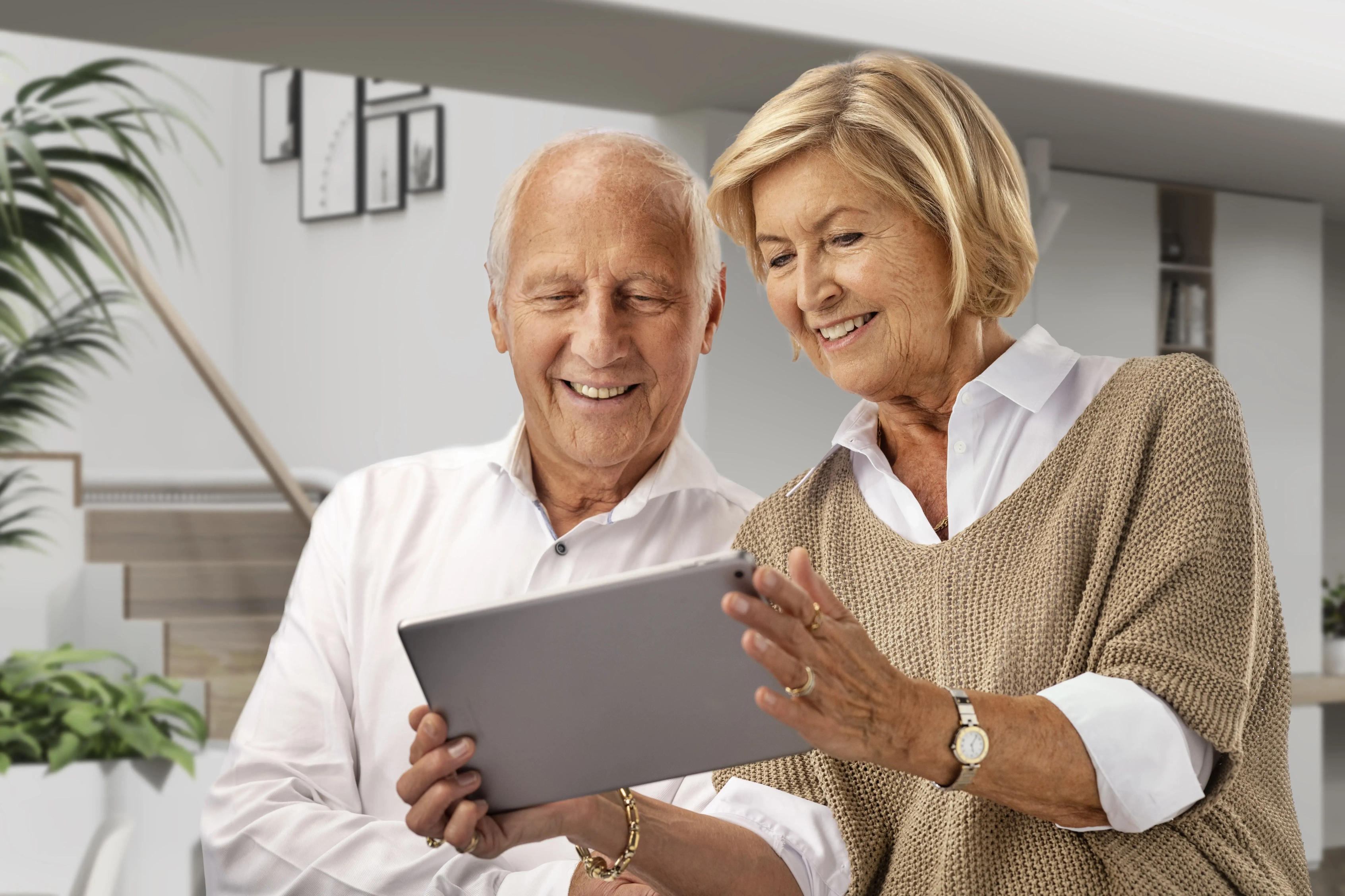 aelteres-paar-informiert sich-online-ueber-treppenlift Ein älteres Paar informiert sich online an ihrem Tablet über Treppenlifte | TK Home Solutions