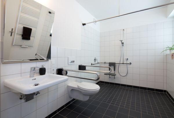 Bad Barrierefrei Ein barrierefreies modernes Bad mit Stützhilfen an Toilette und Dusche.
