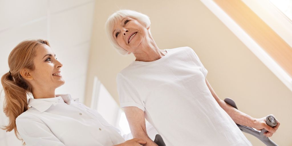 shutterstock_692790184 cropeed Eine alte Frau mit Krücken bekommt Unterstützung beim gehen von einer jungen Ärztin