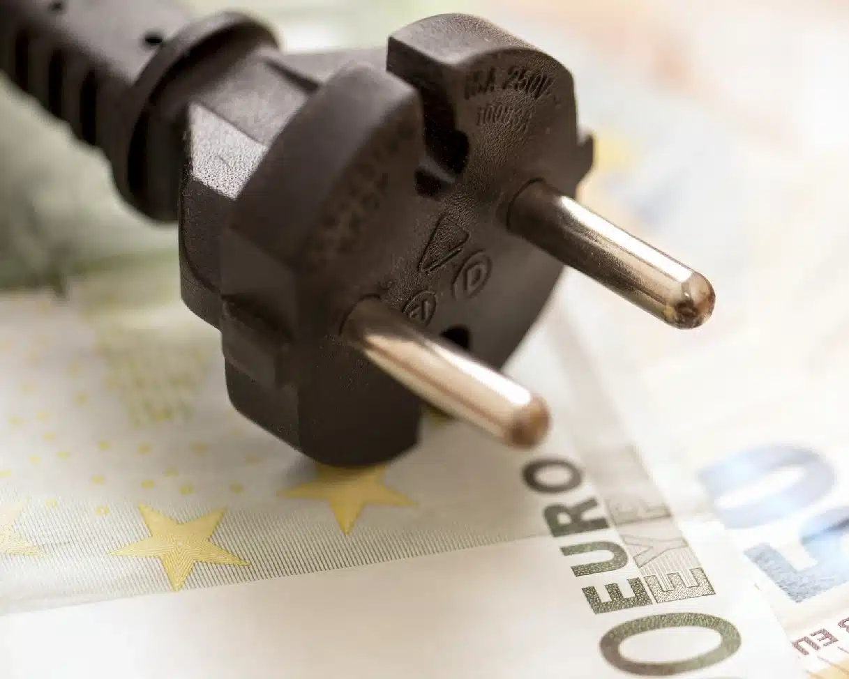 Nahaufnahme eines Stromsteckers auf Euro-Banknoten – Symbolbild für Stromkosten und Energiepreise.